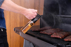 Traeger spritzer spraying brisket to lock in moisture and enhance bark