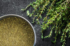 Unpretentious ground thyme spoon portion in bowl ready to season soups and sauces