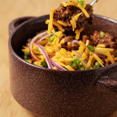 Wick Fowler's chili in pot illustrating rich color and hearty texture