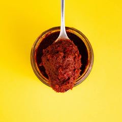 Zwïta jar open with spoon of paste showing thick spreadable consistency