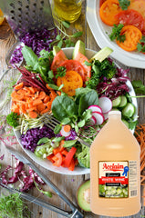 Acclaim white wine vinegar next to fruit and measuring cup showing gallon scale for value