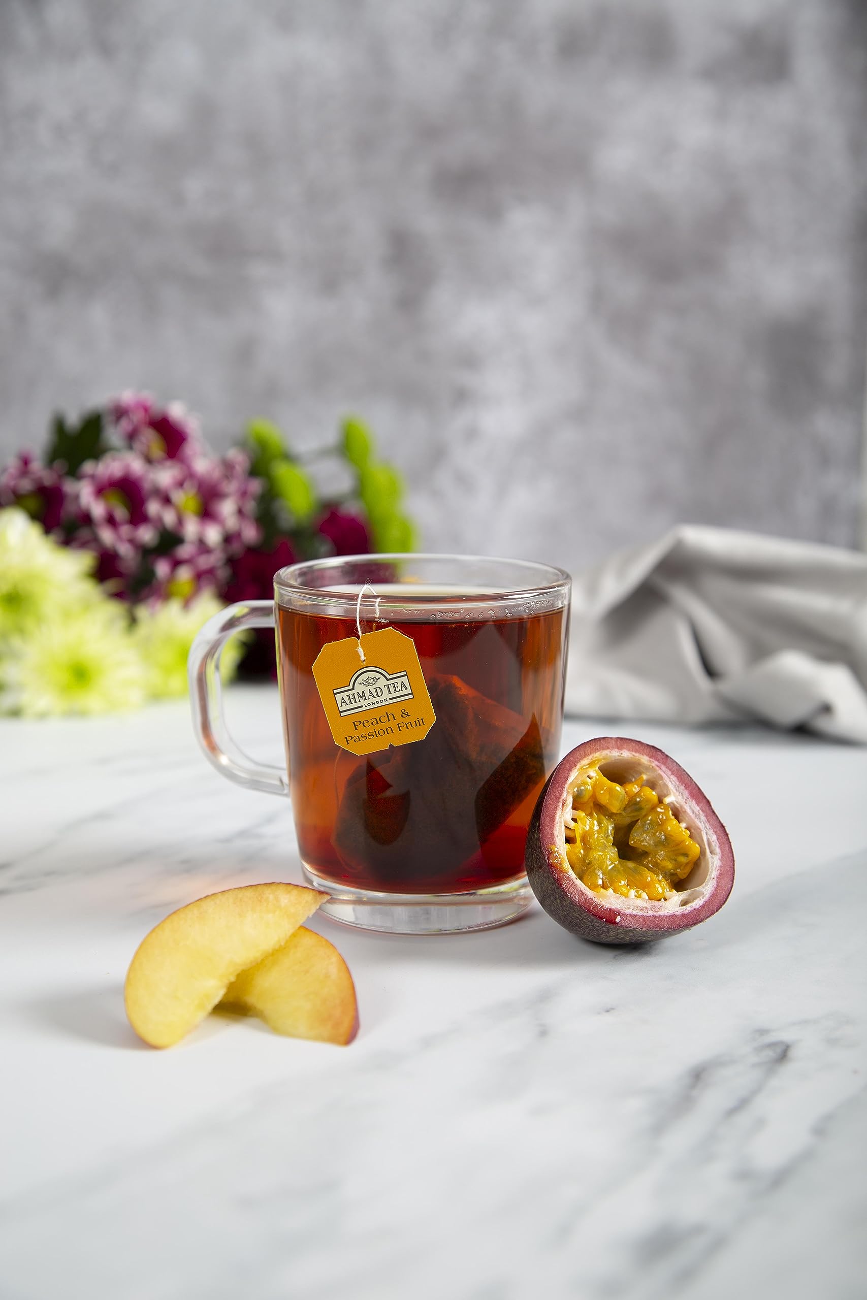 Ahmad Tea poured cup in a kitchen setting illustrating vibrant peach-passion aroma and serving suggestion