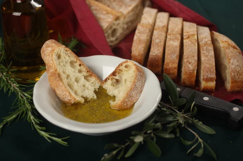 Alessi grinder in use over olive oil for dipping, enhances bread flavor