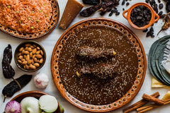 Amazing Chiles & Spices powder being stirred into mole sauce, adding rich color and depth