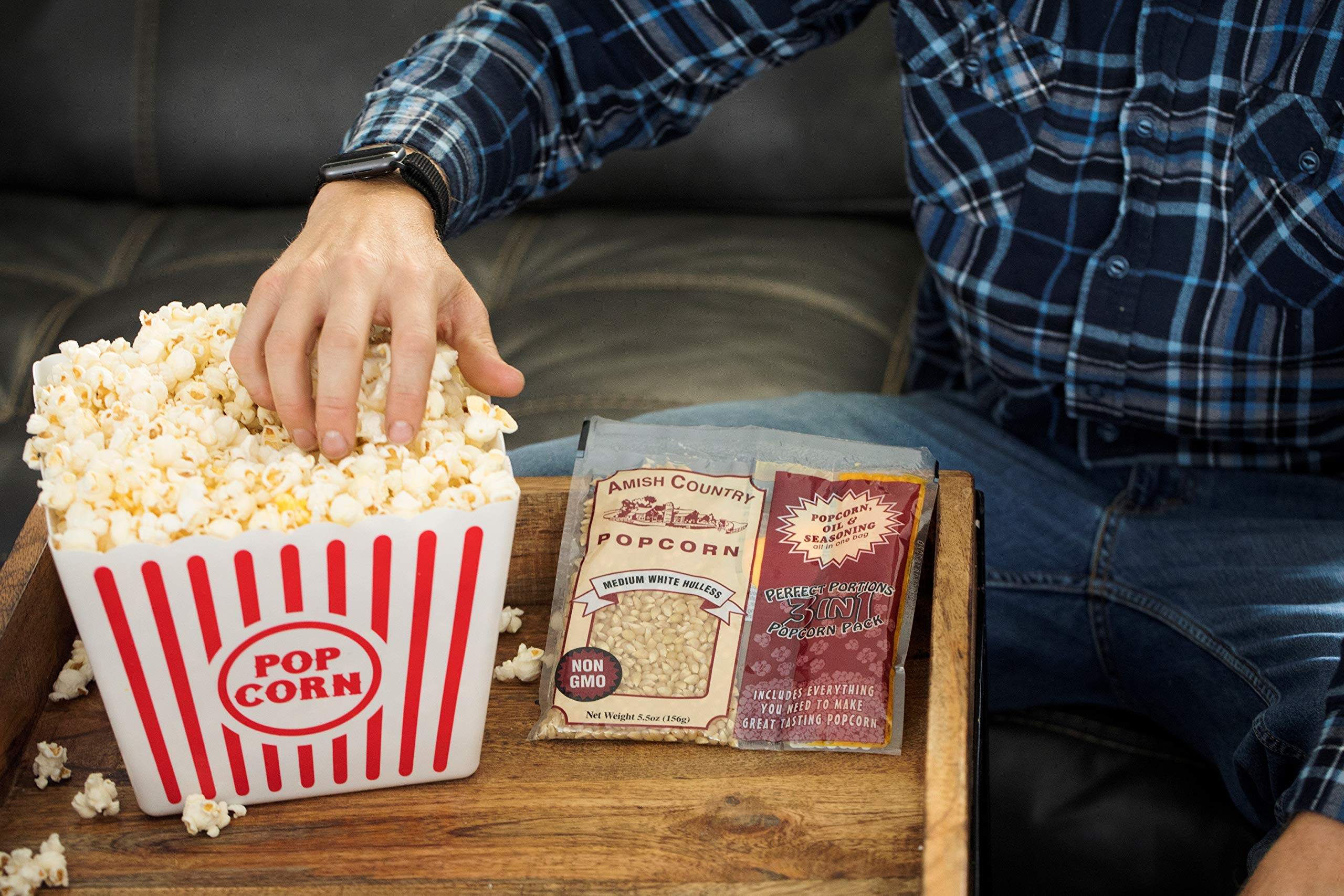 Amish Country Popcorn beside a hand to show single‑bag portion size