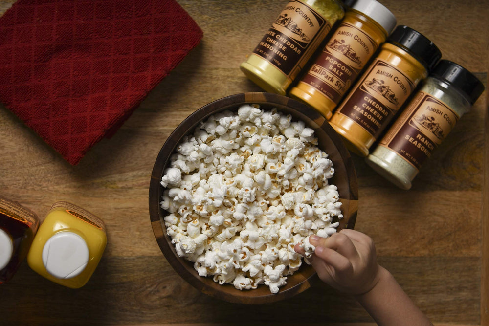 Amish Country Popcorn seasoning jar held in hand showing scale and ideal portion sizing