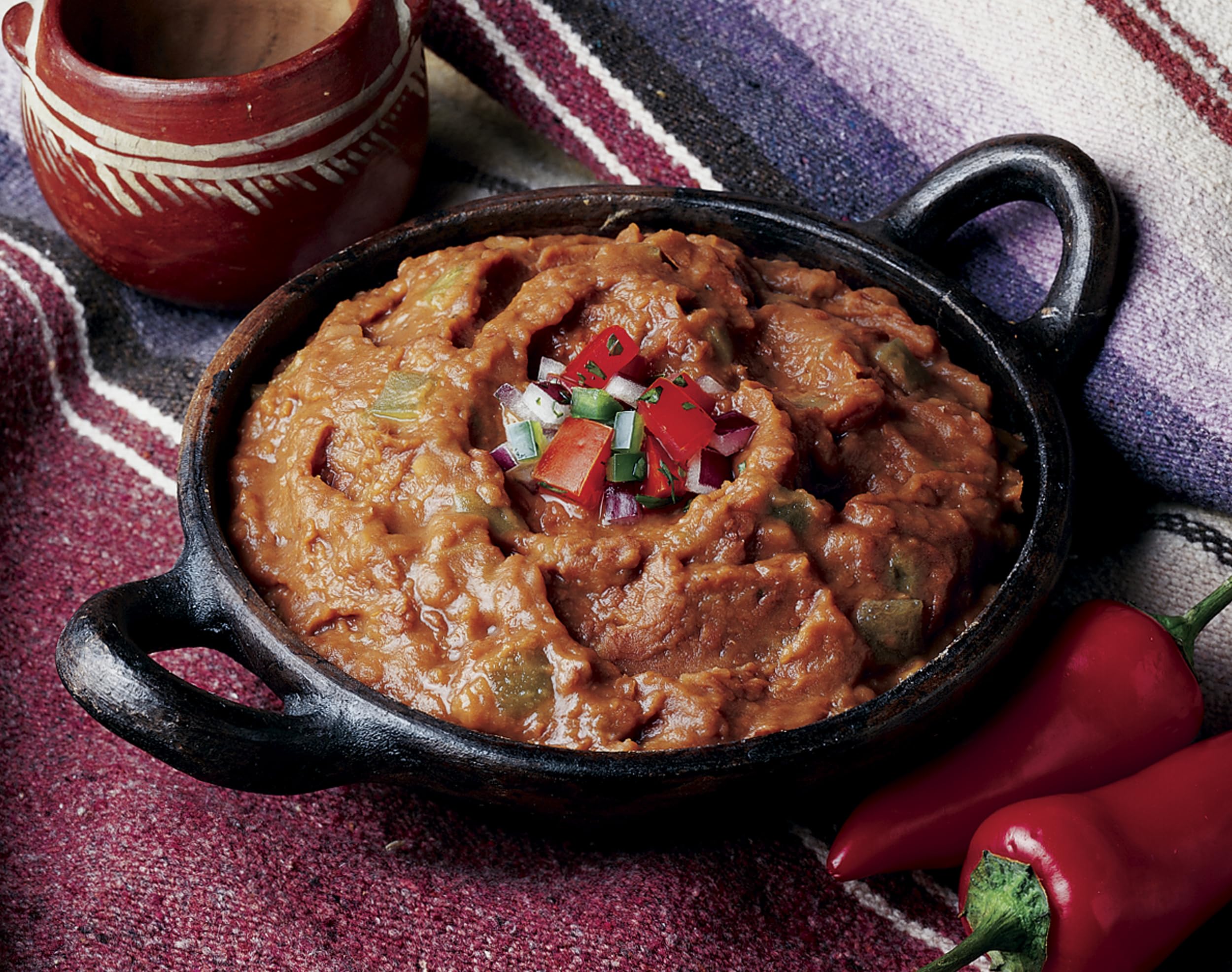 Amy's open can revealing creamy refried beans texture and green chile pieces for quick meals