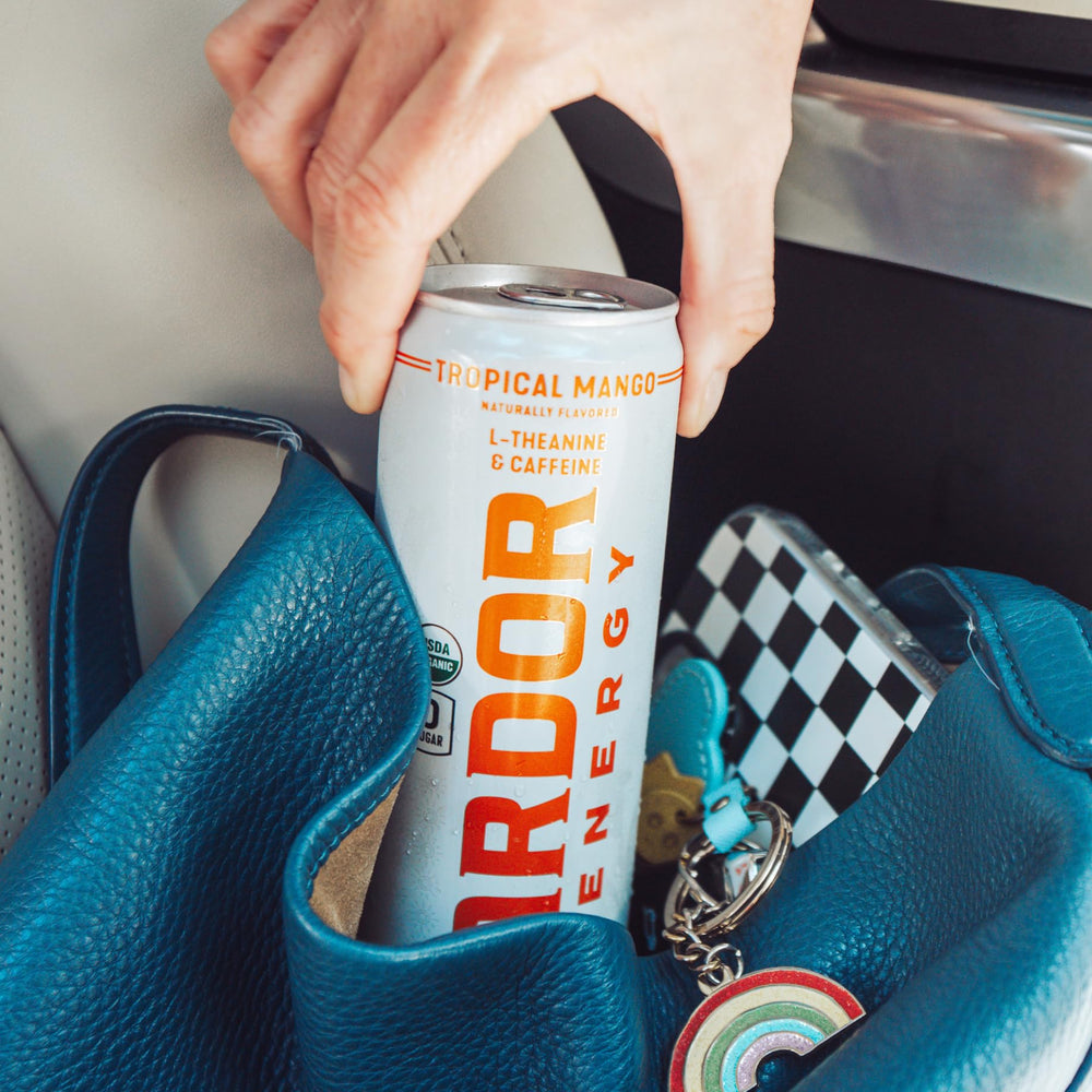 ARDOR energy grapefruit pack next to a phone showing 12-can convenience