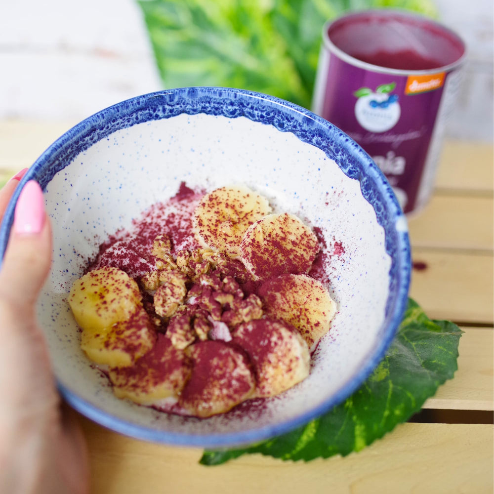 Aronia Original spoon added to smoothie bowl showing vibrant color and thicker texture benefit