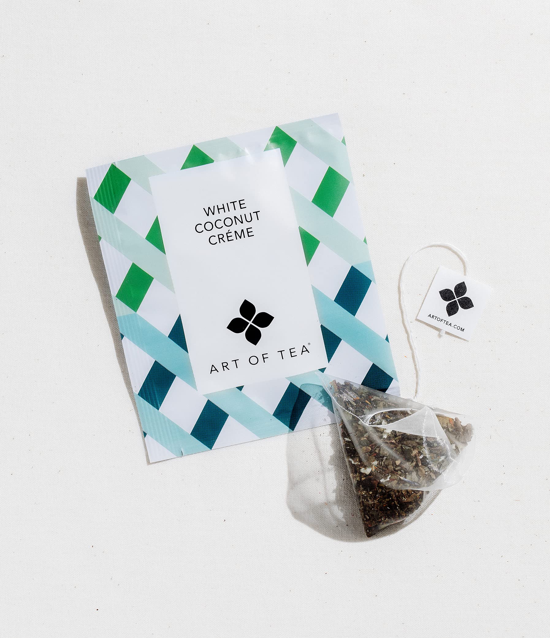 Art of Tea sachet next to teaspoon showing single-serve portion size