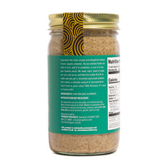 Artisana spoon scooping almond butter highlighting spreadable consistency and recipe-friendly benefit