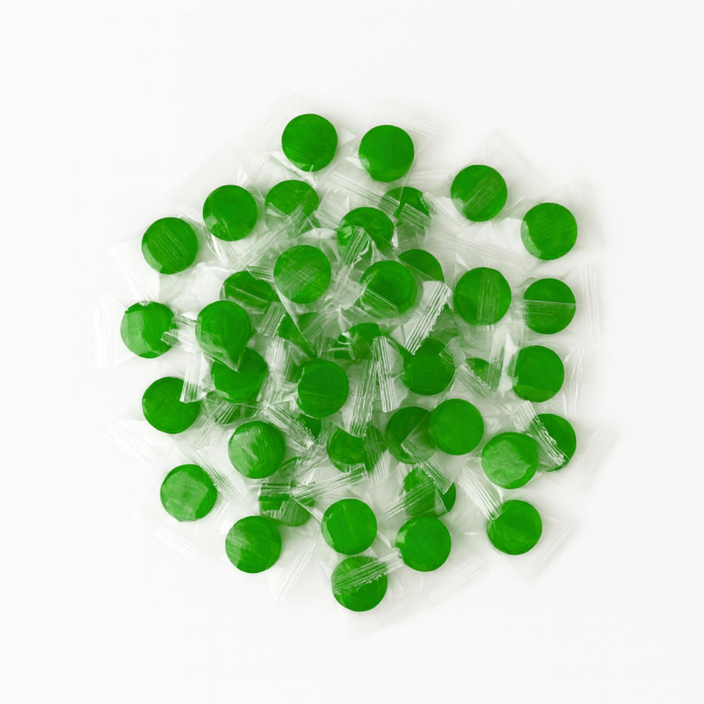Assortit candies in a clear bowl for party display, colorful green accent for events