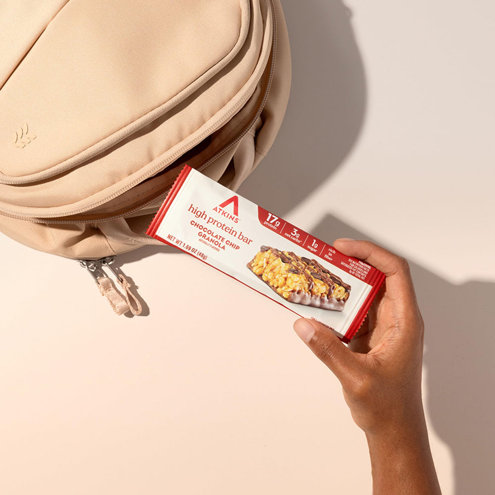 Atkins bar in a backpack pocket as a travel snack for quick protein support