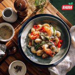 Badia white pepper sprinkled into cream sauce showing brand in use for subtle, uniform seasoning