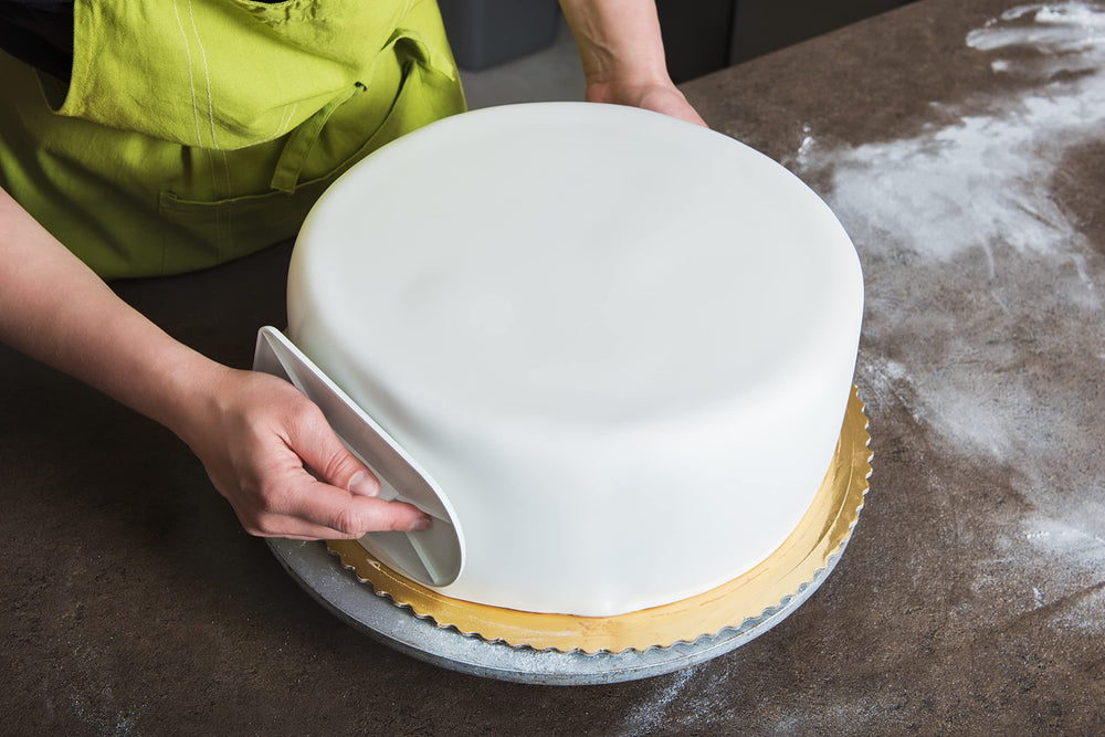 Hands kneading Bakerpan fondant illustrating easy handling and pliability while prepping