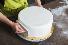 Hands kneading Bakerpan fondant illustrating easy handling and pliability while prepping