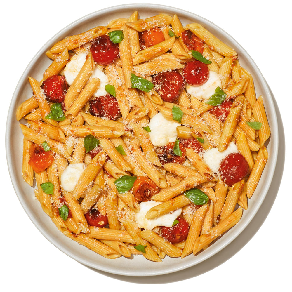 Banza uncooked penne being poured from box demonstrating easy portioning