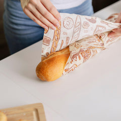 Bee's Wrap wrapped around a baguette in hand showing secure transport benefit