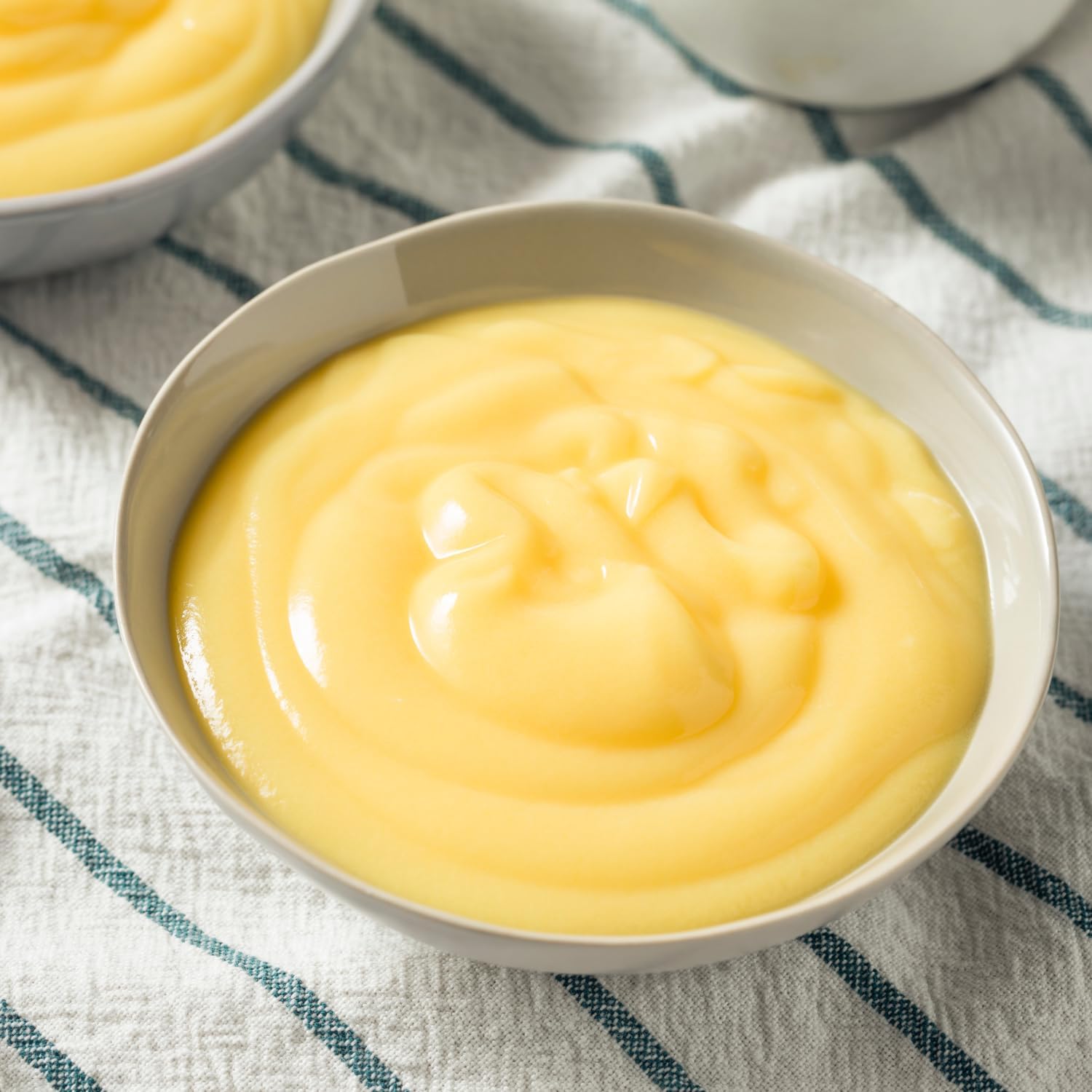 Bird's custard sauce poured over warm apple pudding for comfort