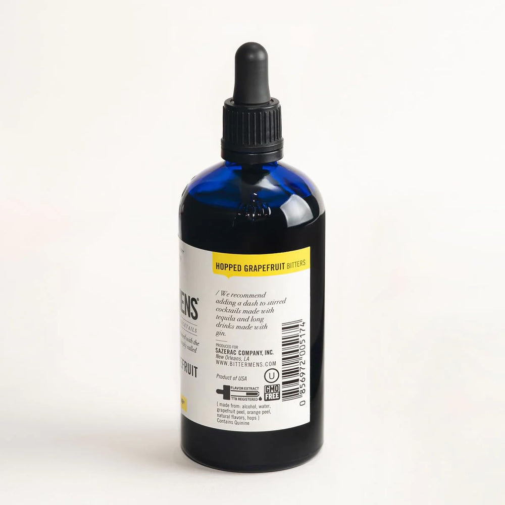 Bittermens bitters bottle beside a grapefruit cocktail, enhancing aroma and balance