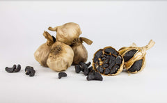 Black Garlic North America cloves on a spoon ready to add concentrated flavor