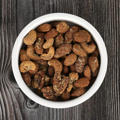 BobbySue's close-up of almonds cashews pecans with seasoning, emphasizes crunchy texture