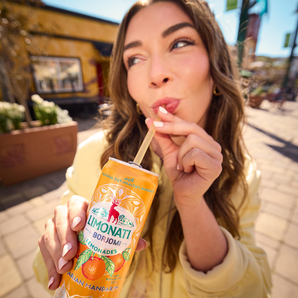 BORJOMI can in hand for scale highlighting portable single-serve convenience