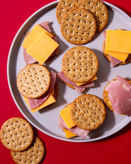 Breton cracker topped with cheese and fruit illustrating versatile pairing options