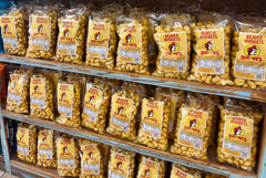 Hand holding one 13 oz Buc-ee's bag to show size and portability for travel