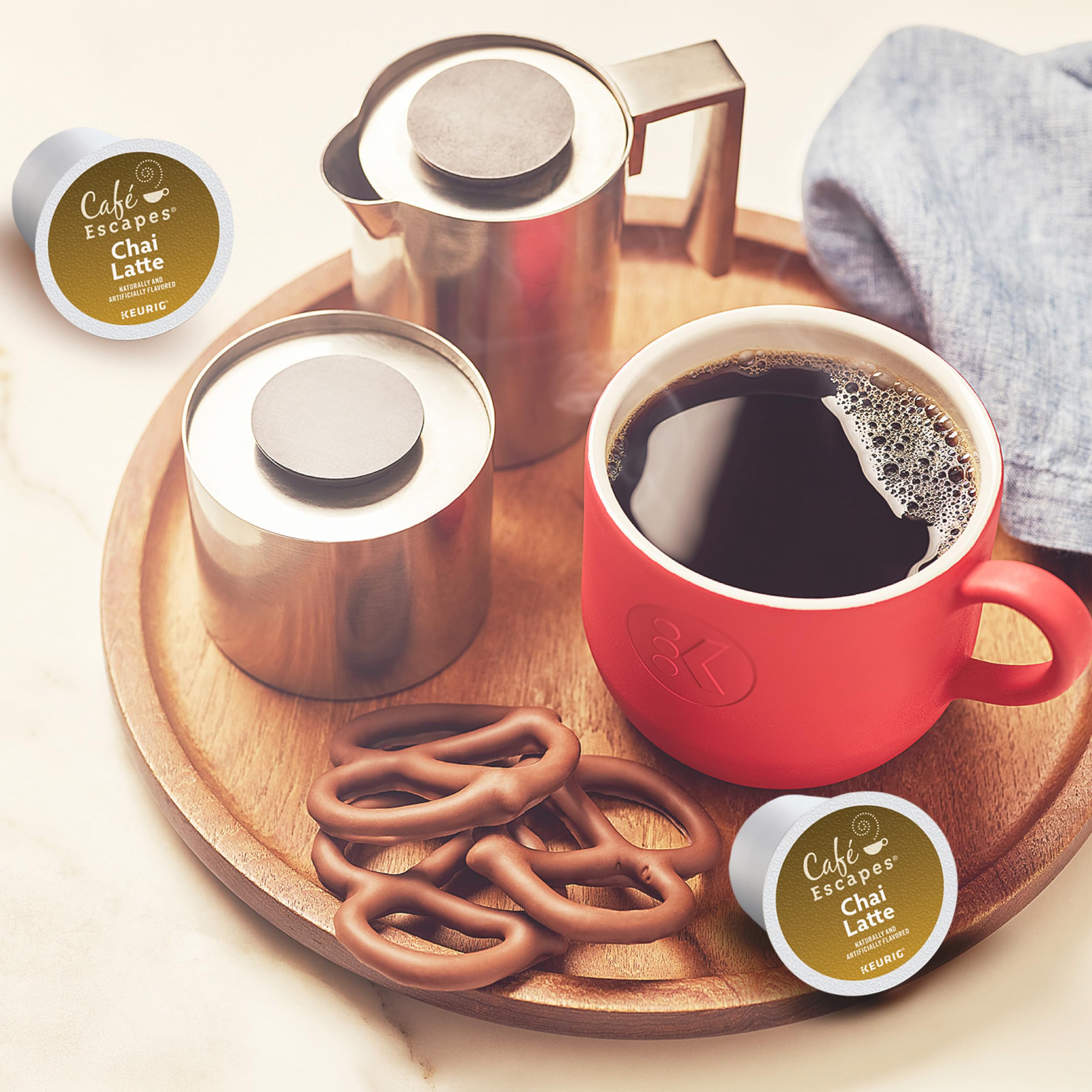 Café Escapes pod held in hand illustrating single-serve scale and portability benefit