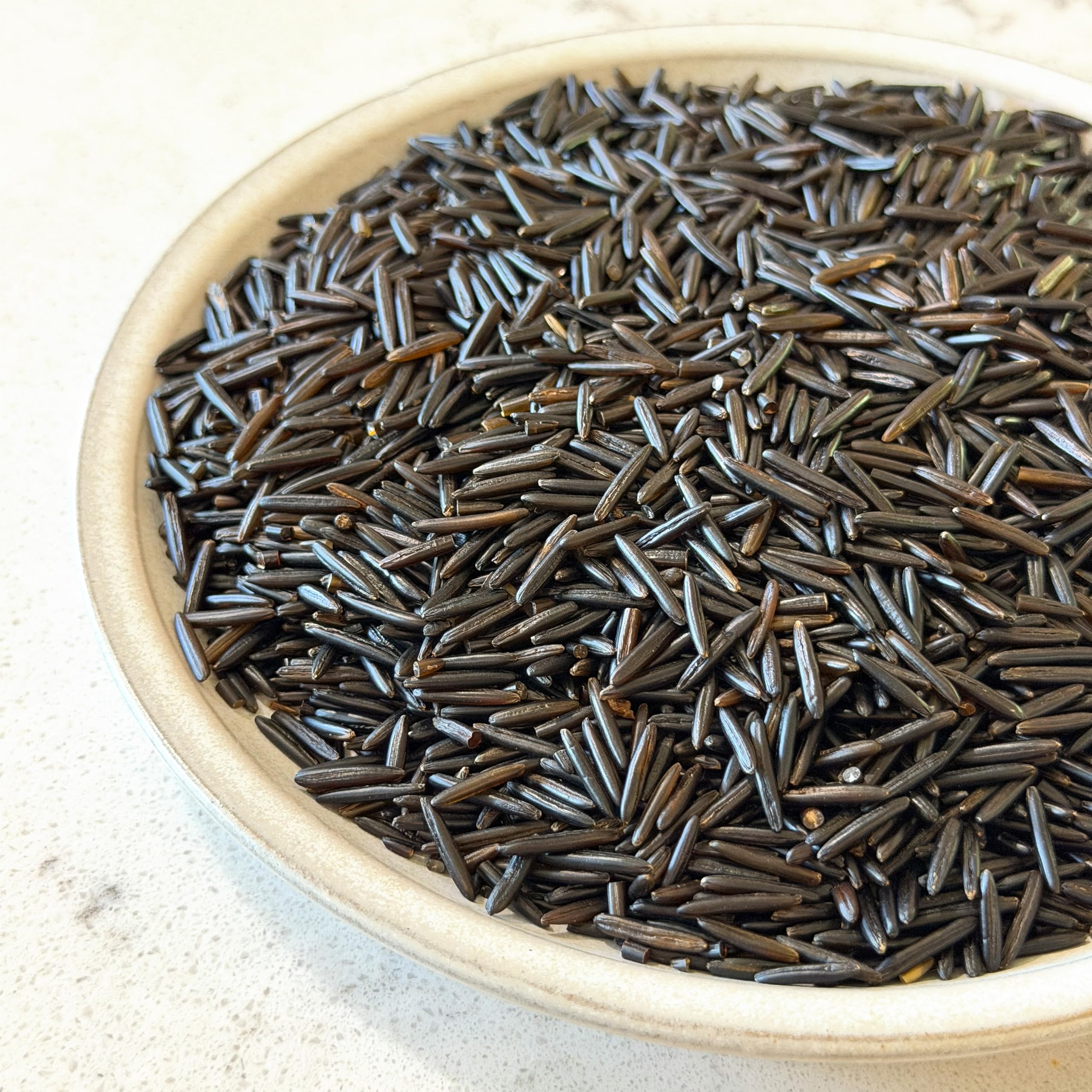 Canoe wild rice simmering in pot demonstrating firm grains and cooking result