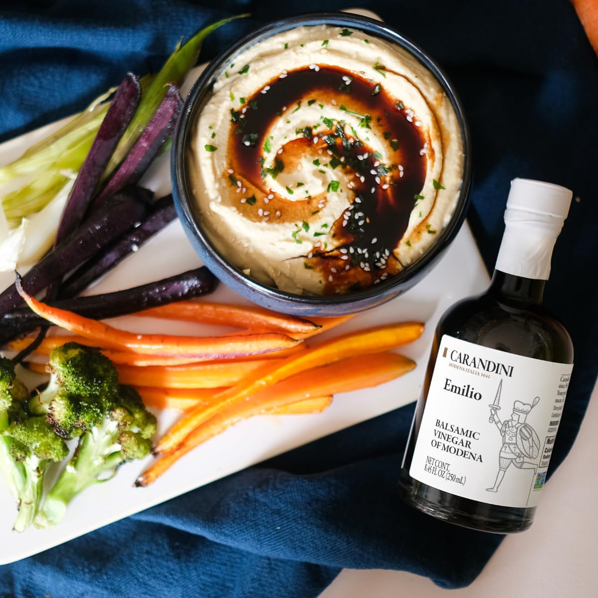 Carandini bottle beside cheese board showing pairing and presentation benefit