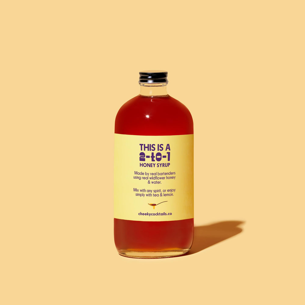 Cheeky honey syrup on a bar counter with tools, ideal for quick cocktail preparation