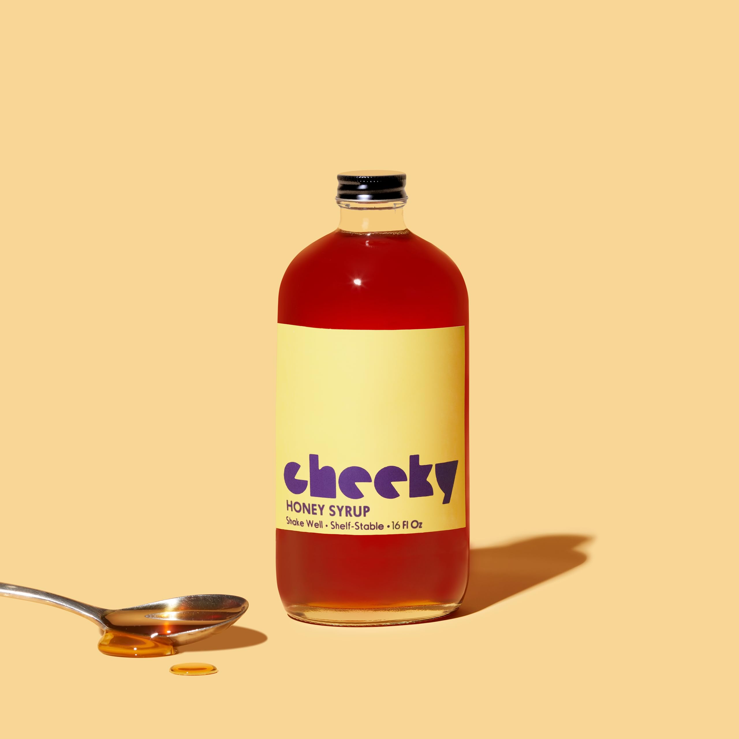Cheeky honey syrup size comparison held in hand, illustrating the 16 fl oz practical volume