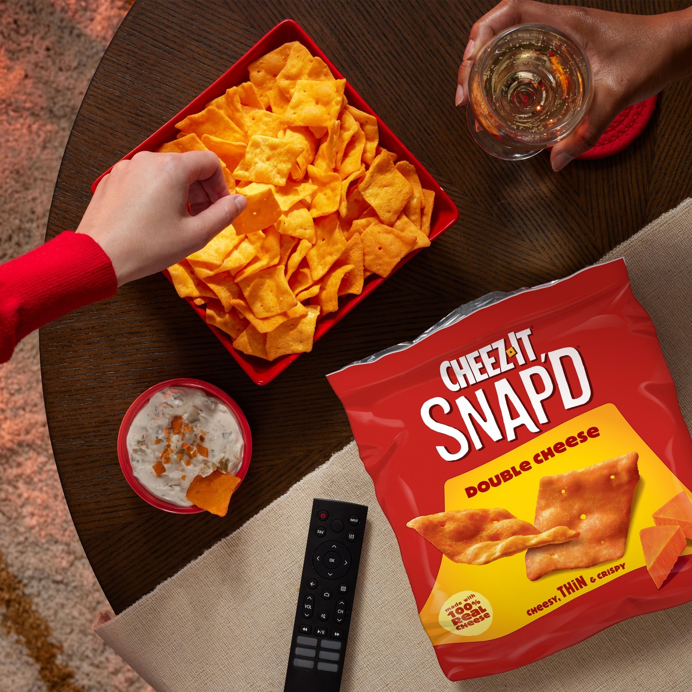 Cheez-It Snap'd hand holding single crisp showing portion size advantage