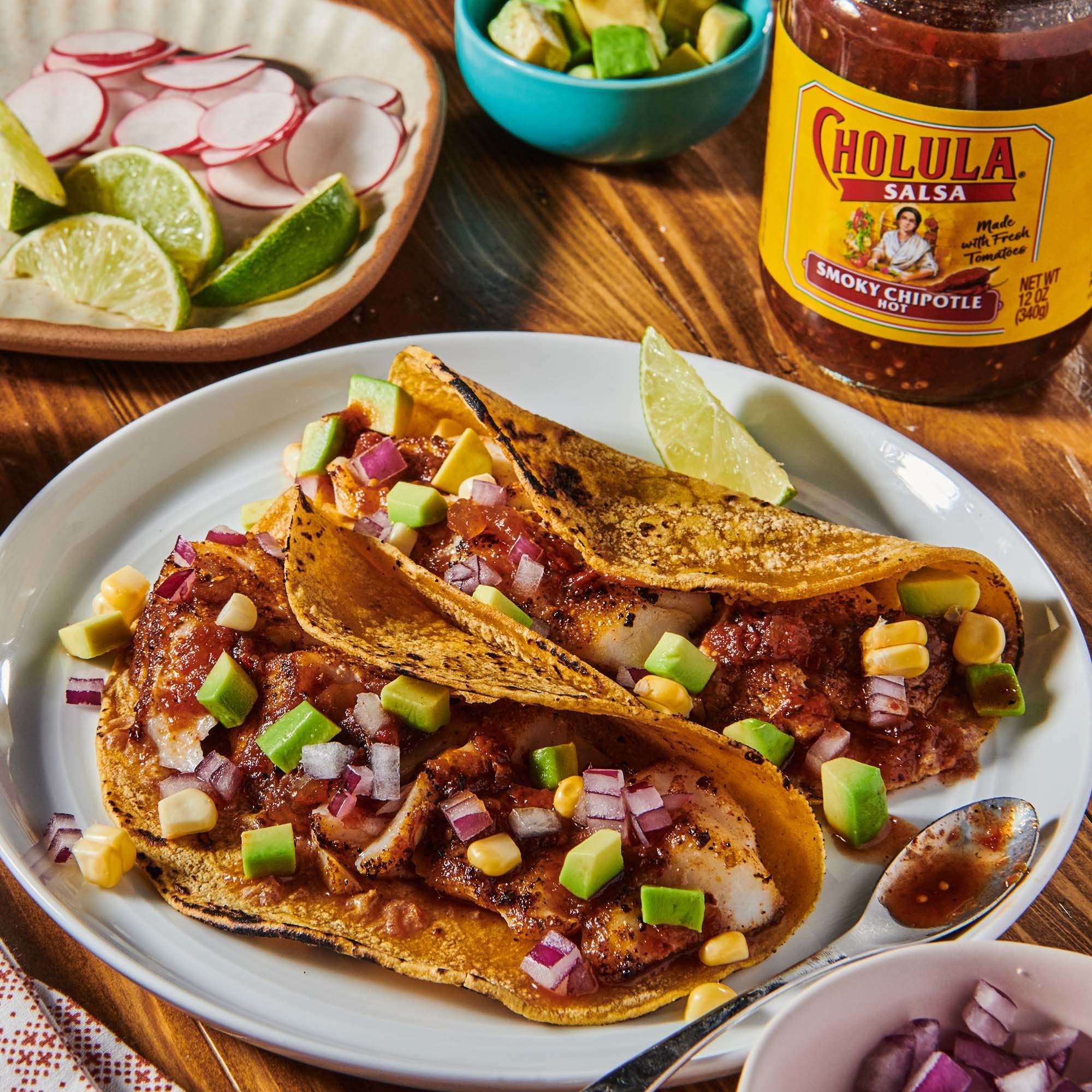 Kitchen table spread with Cholula smoky chipotle salsa served for tacos and entertaining.