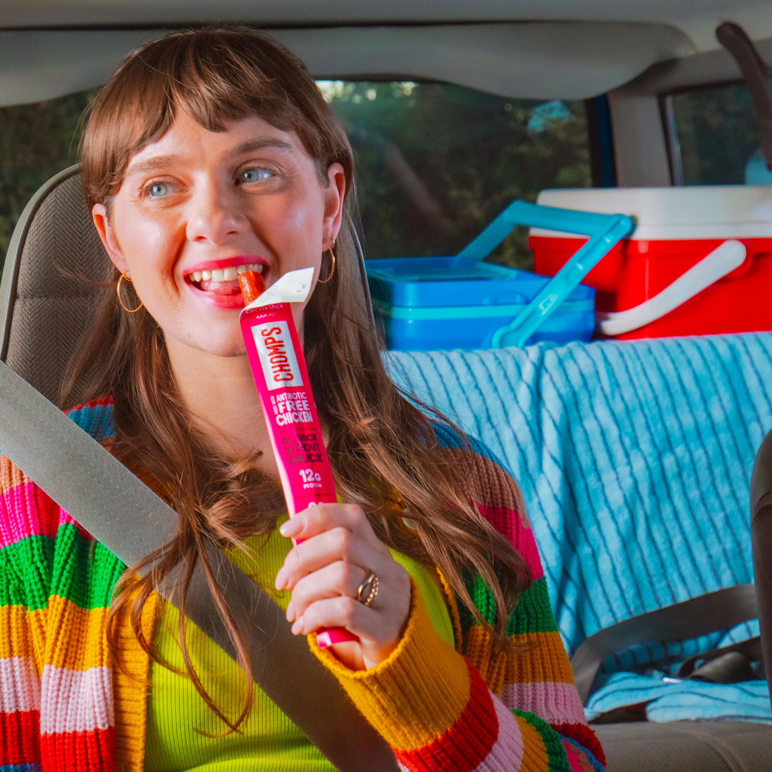 Chomps stick next to a phone illustrating compact size and easy carrying