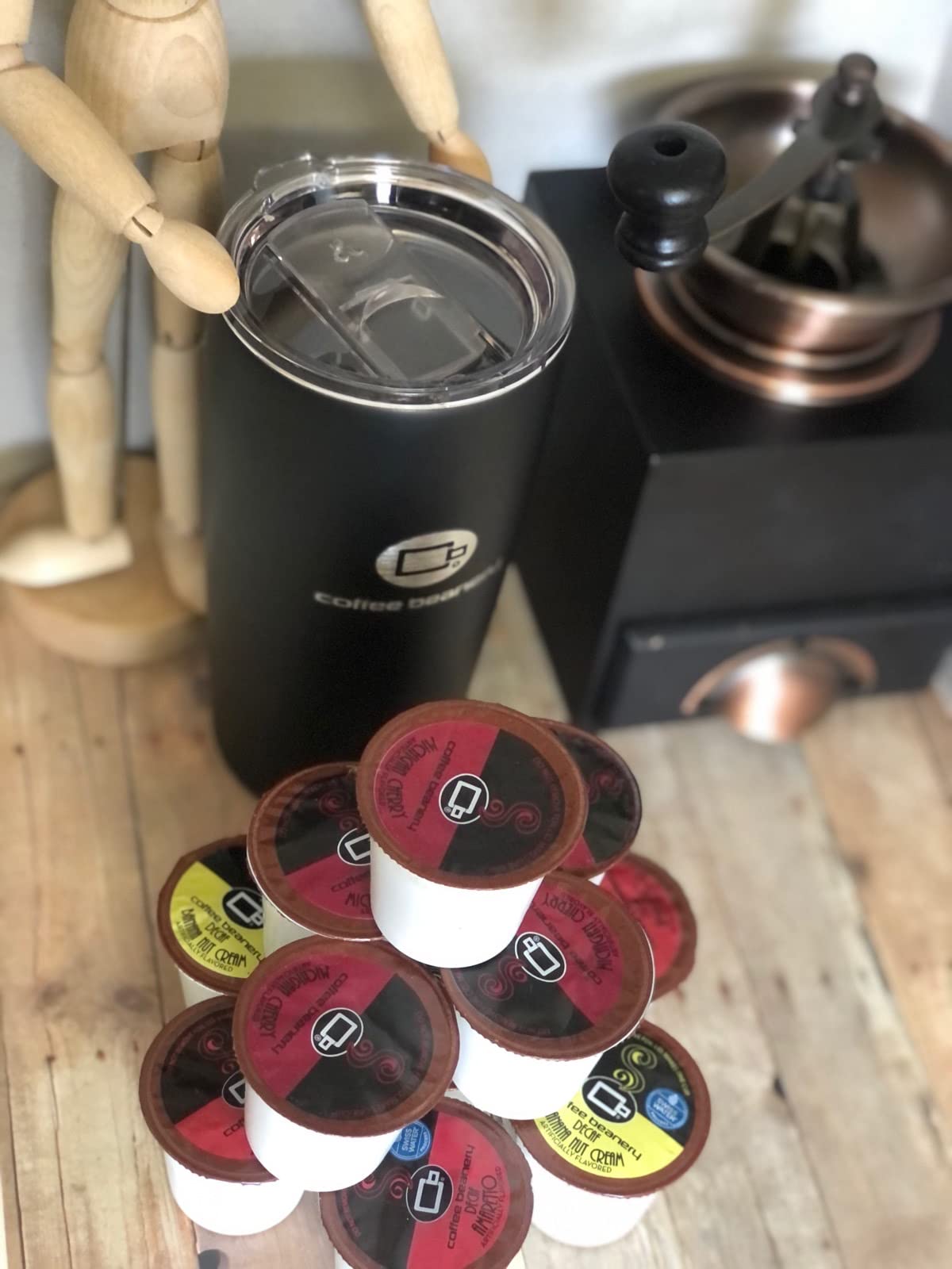 Coffee Beanery pod held in hand next to cup showing scale and easy single-serve convenience