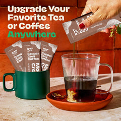 Copper Cow Coffee packet being poured into a hot cup illustrating smooth blend and quick mixing