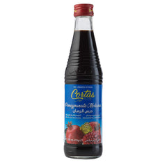 Cortas pomegranate molasses pour closeup over spoon, showing thick texture and rich color