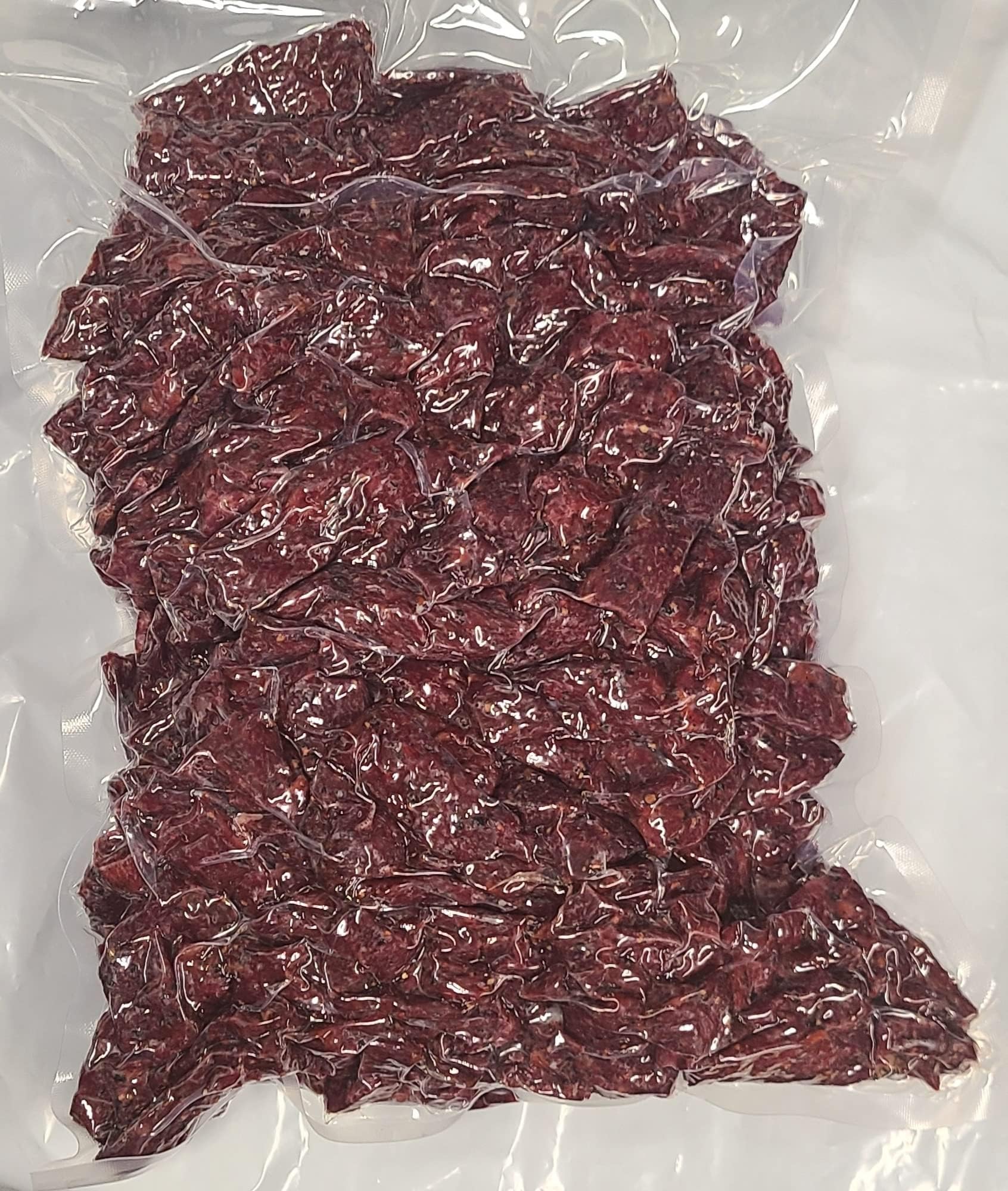 Dakota Trails jerky on campsite plate showing peppered flavor benefit as satisfying group snack