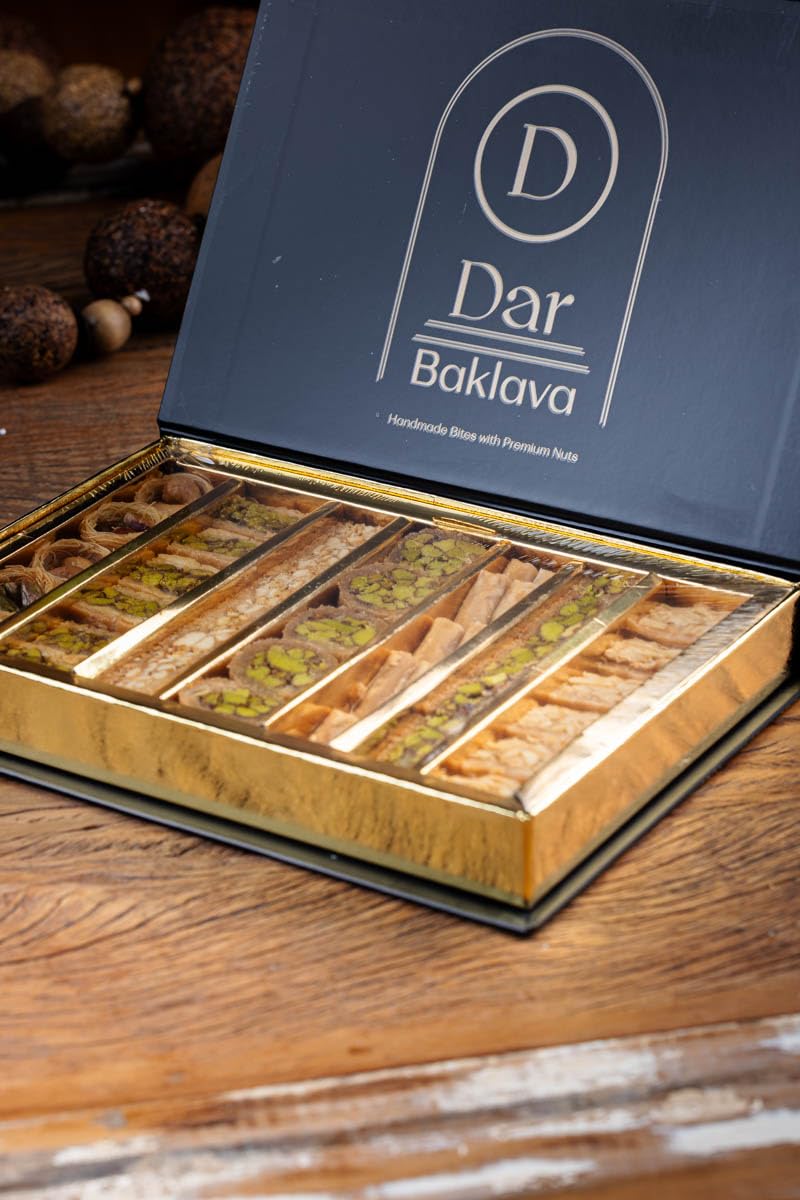 DAR BAKLAVA next to a hand for scale showing bite-sized portions and convenience