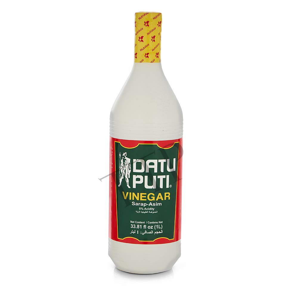 Datu Puti bottle on table next to dipping sauce and fresh ingredients