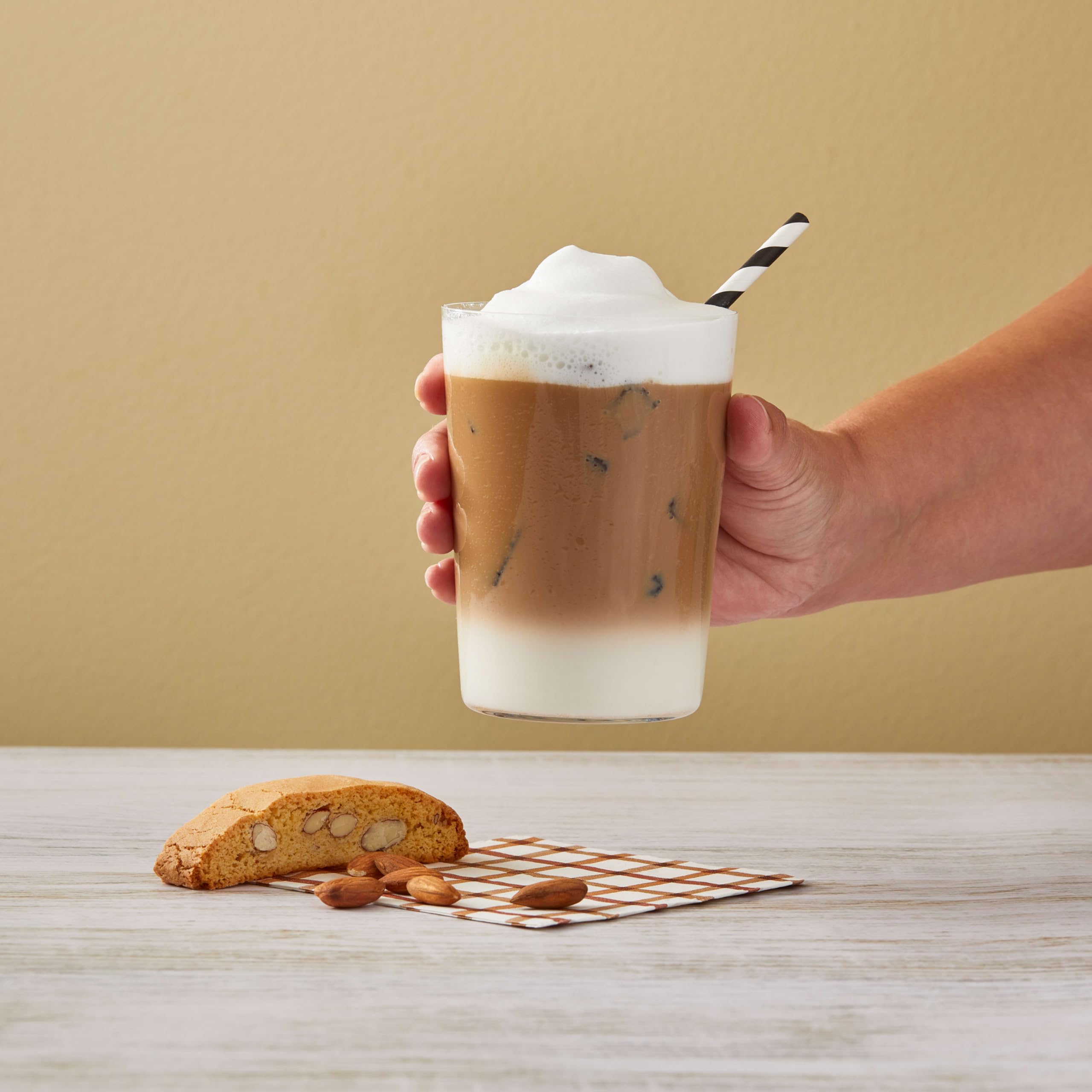 DaVinci Gourmet almond syrup bottle next to a measuring cup showing scale
