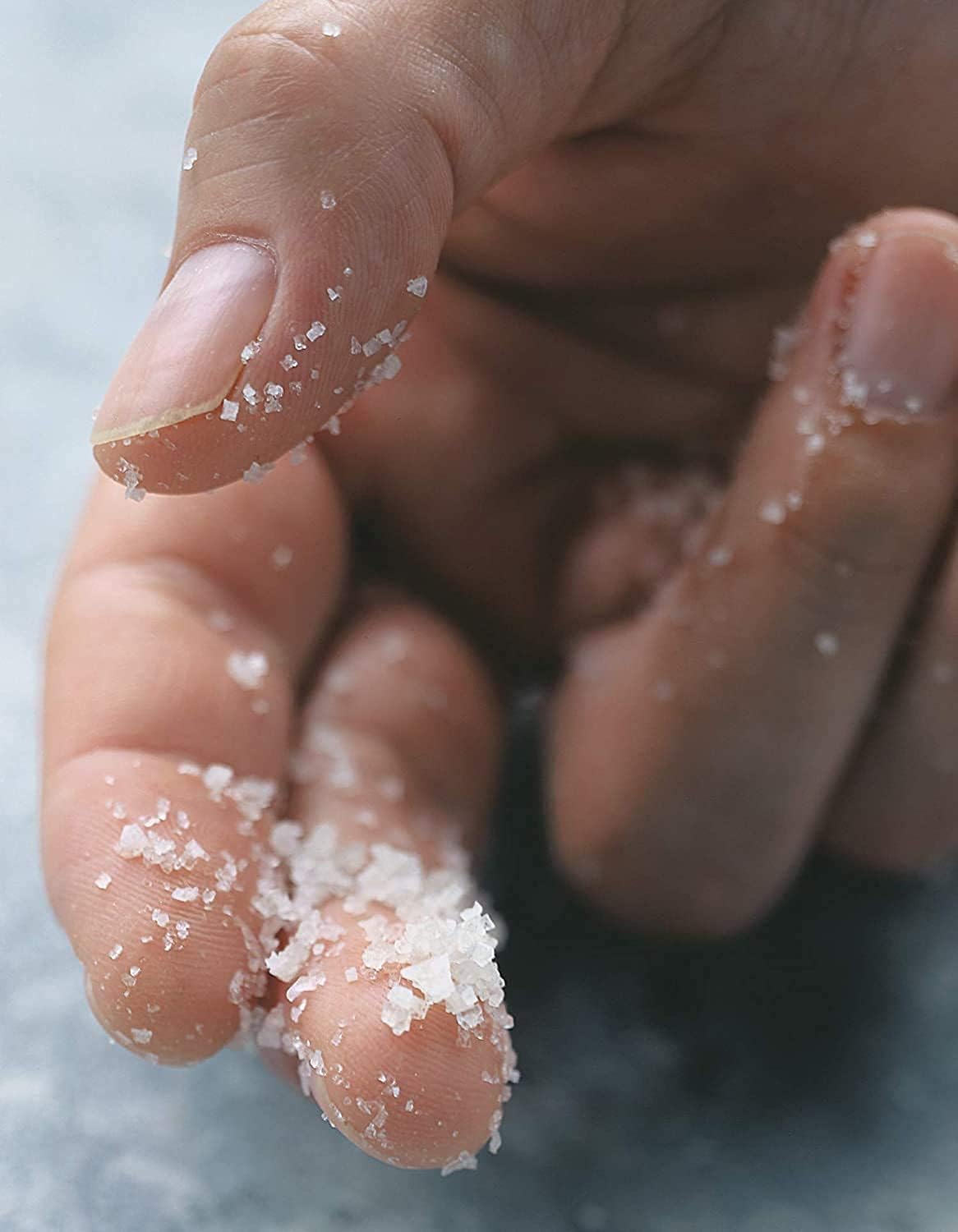 Hand pinching Diamond Crystal kosher salt illustrating easy fingertip control and even distribution