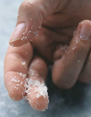 Hand pinching Diamond Crystal kosher salt illustrating easy fingertip control and even distribution