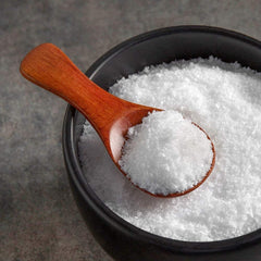 Pouring Diamond Crystal kosher salt over a grilled steak to enhance finishing flavor