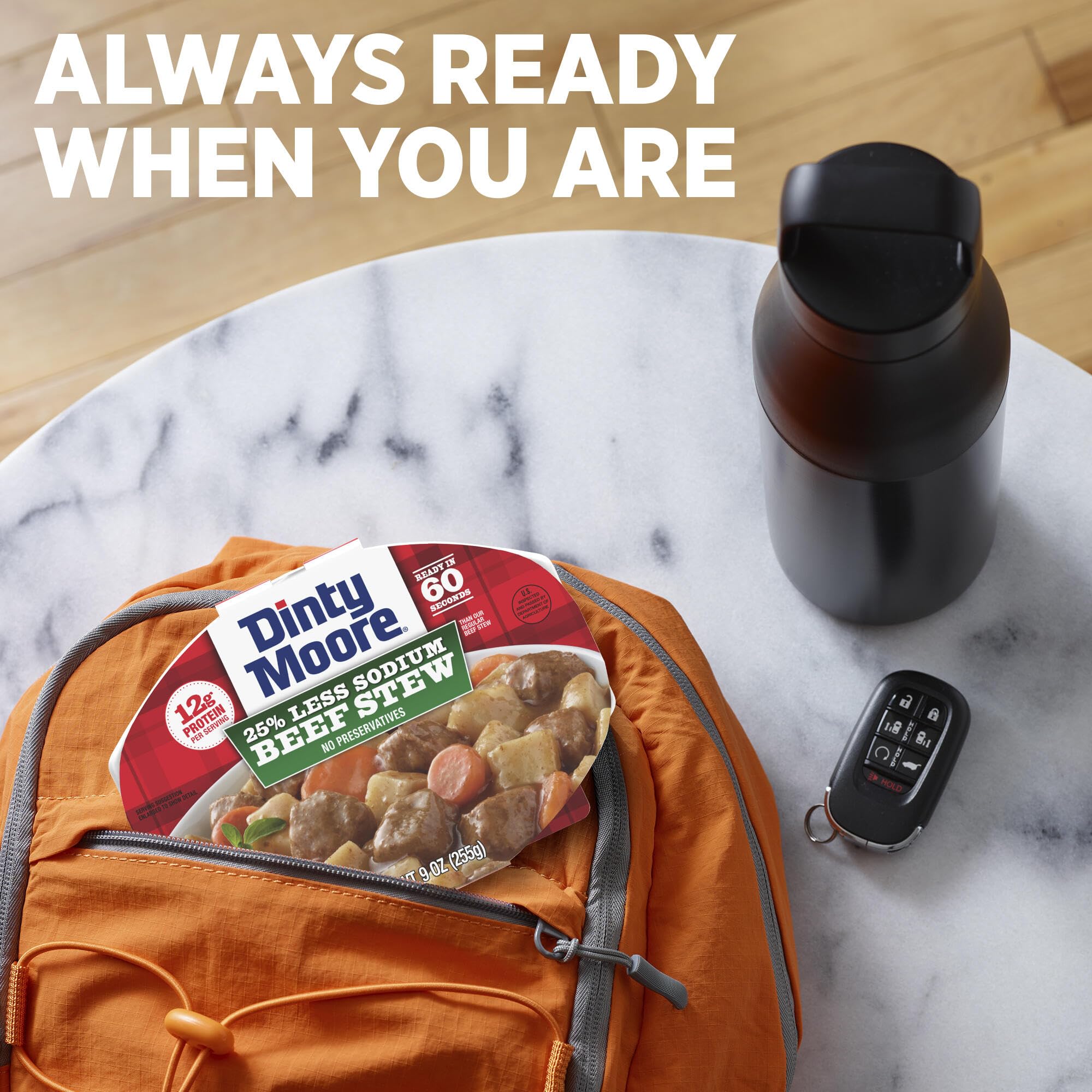 Dinty Moore tray held in hand showing 9oz size and portable convenience
