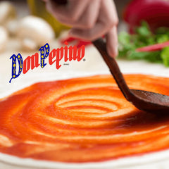 Don Pepino sauce being spread on pizza dough to ensure even coverage and flavor