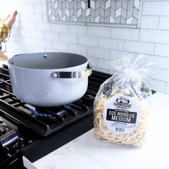 Dry Farmhouse Preserve noodle pile next to a measuring cup showing portion size